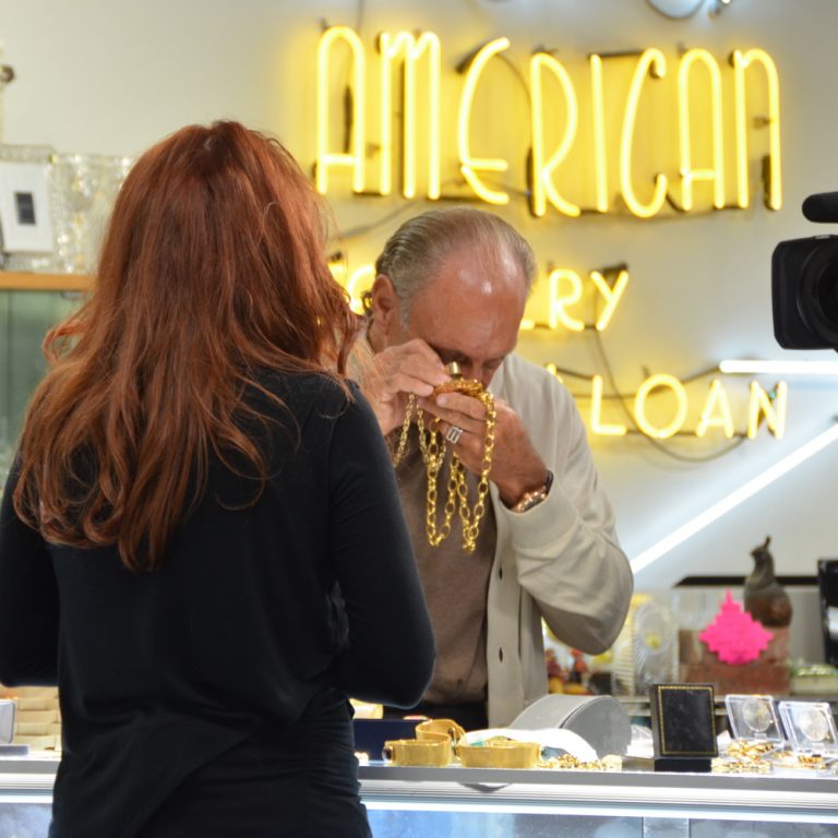 Les Gold using a loup to inspect the karat of a gold chain.